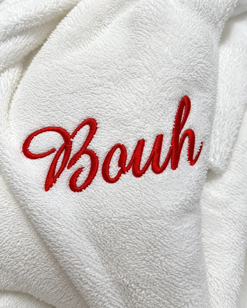 Surnom « Bouh » brodé en fil rouge sur une éponge blanche