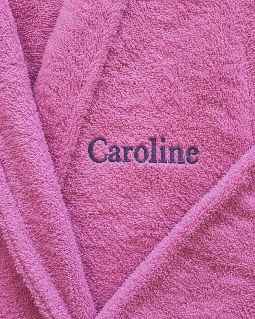 Prénom « Caroline » brodé en fil violet sur une éponge rose