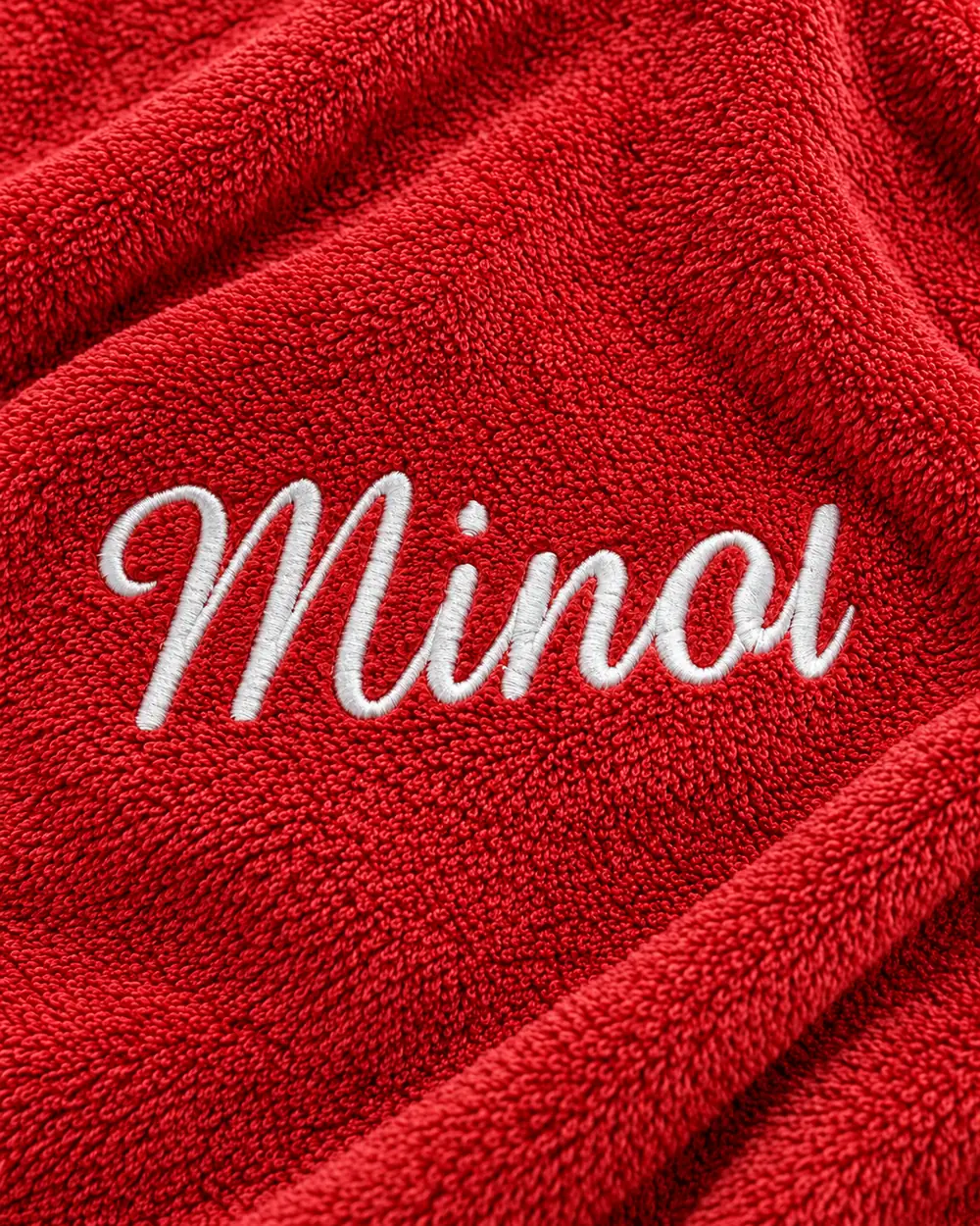 Surnom « Minou » brodé en fil blanc sur une éponge rouge