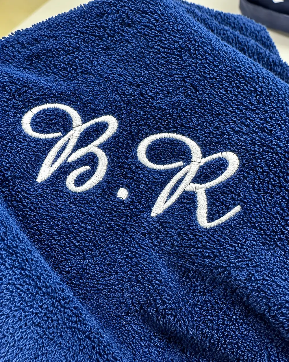Peignoir bleu marine brodé aux initiales « B.R » en fil blanc, pour le marié