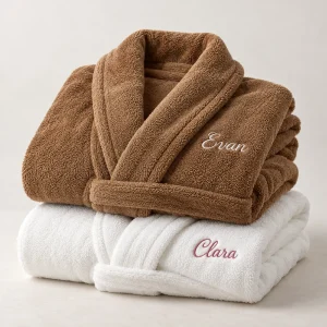 Deux peignoirs personnalisés pour couple, marron et blanc, brodés aux prénoms « Evan » et « Clara »