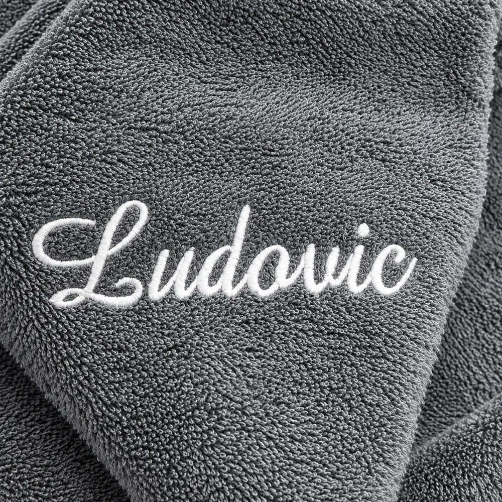 Serviette de bain personnalisée grise, brodée au prénom « Ludovic » en fil écru