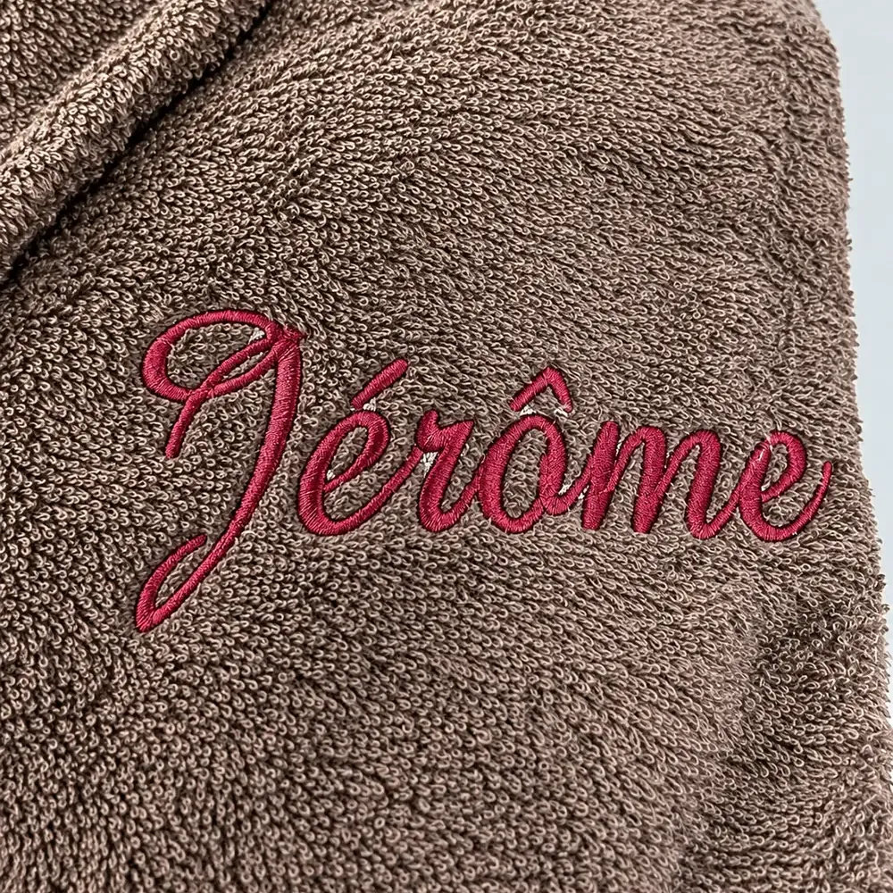 Serviette de bain personnalisée taupe, brodée au prénom « Jérôme » en fil framboise