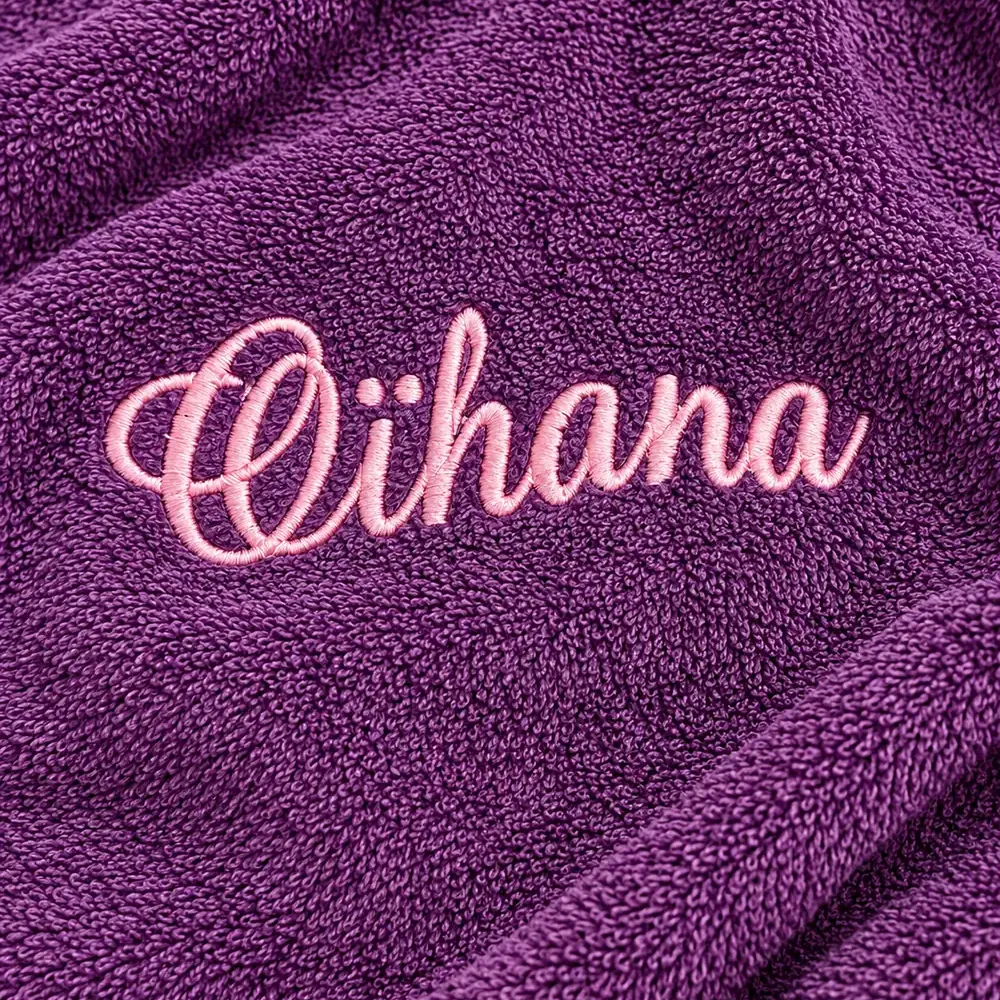 Serviette de bain personnalisée violette, brodée au prénom « Oïhana » en fil rose